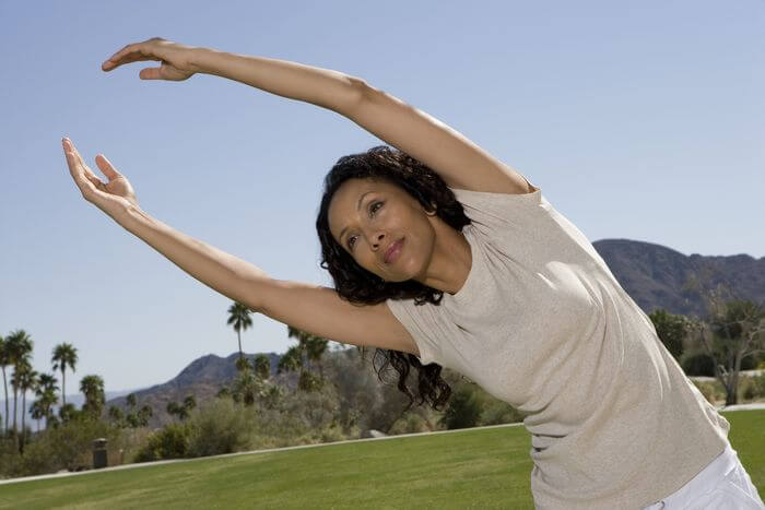 Woman stretching and warming up outdoors in a park.