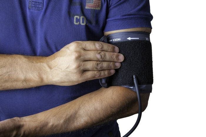 Man measuring blood pressure using the pressure sleeve.