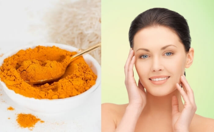Women with beautiful face skin, touching her skin on face and feeling wonderful about her skin. A bowl (with spoon) full of turmeric powder placed on the left.