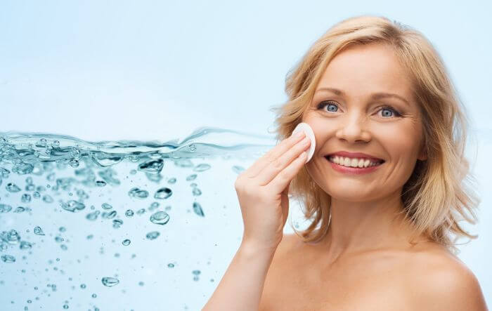 Smiling woman, happy about fresh, smooth, and exfoliated skin on her face and neck